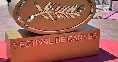 Gold sculpture featuring the Palm d'Or emblem and the words 'Festival de Cannes' on a pink-carpeted platform at the Cannes Film Festival.]