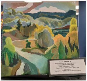 Impressionistic landscape painting of a winding road through green hills and distant mountains, on display with a placard.
